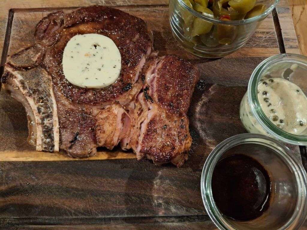 Steak hovězí entrecote udělaný jako krvavý s bylinkovým máslem a různými dipy